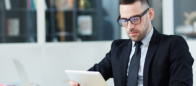young male employee reads tablet